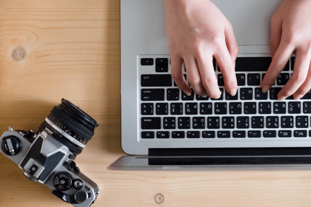 Man's hands on the keyboard next to the camera