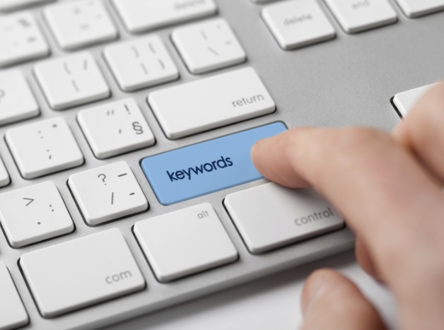 Hand pressing Enter key with the word 'keywords”